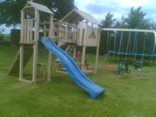 Custom made wooden play frame. Wooden garden climbing frame comes complete with different sizes of slide, and different types of swings in a wide range of colours. The garden climbing frame is designed for private use.